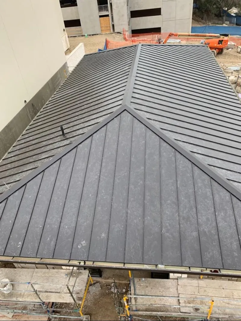 Commercial metal roof construction with crane equipment in Wellington